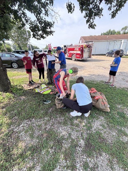 Youth trying on firefighter gear at a community event